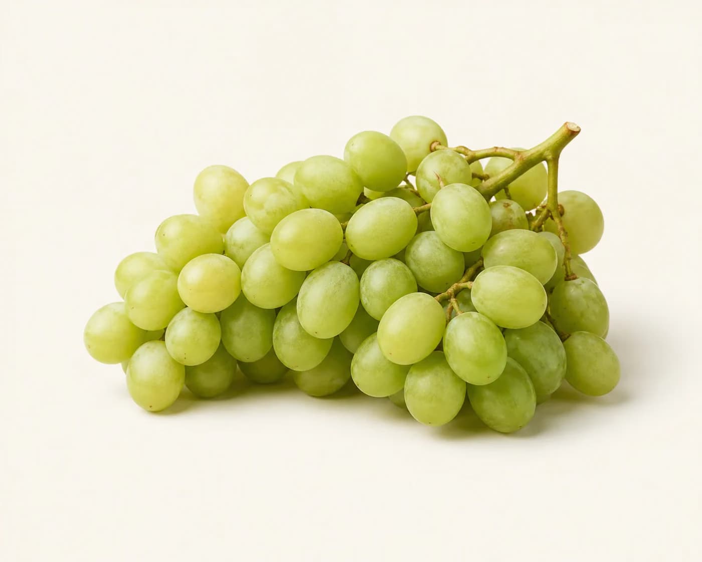 Fresh Thompson Seedless Grapes arranged on a warm off-white surface.