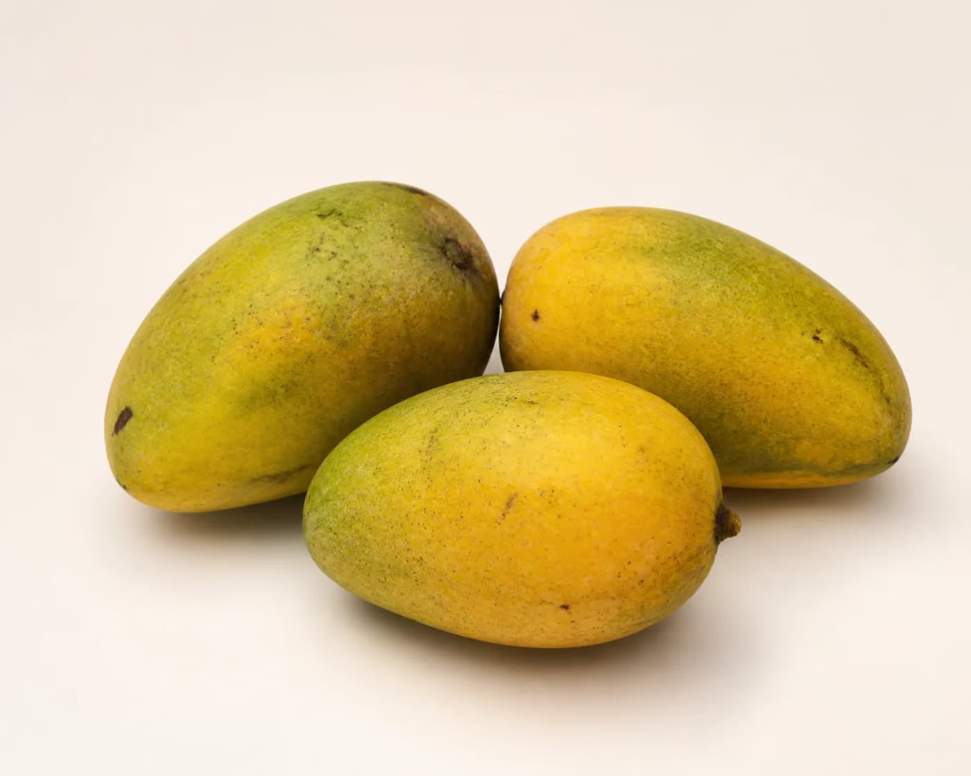 Fresh Neelam Mango arranged on a warm off-white surface.