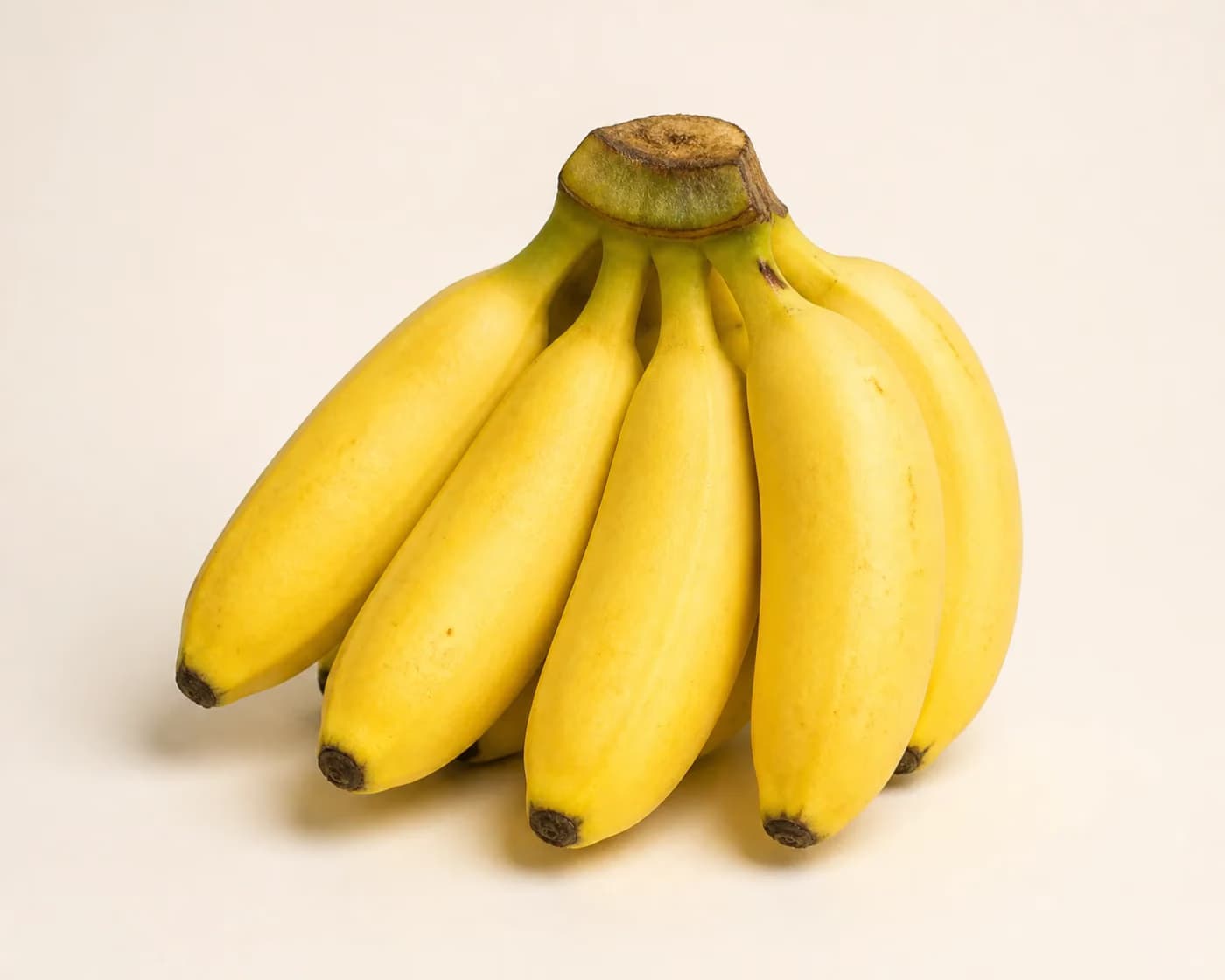 Fresh Rasthali Banana arranged on a warm off-white surface.