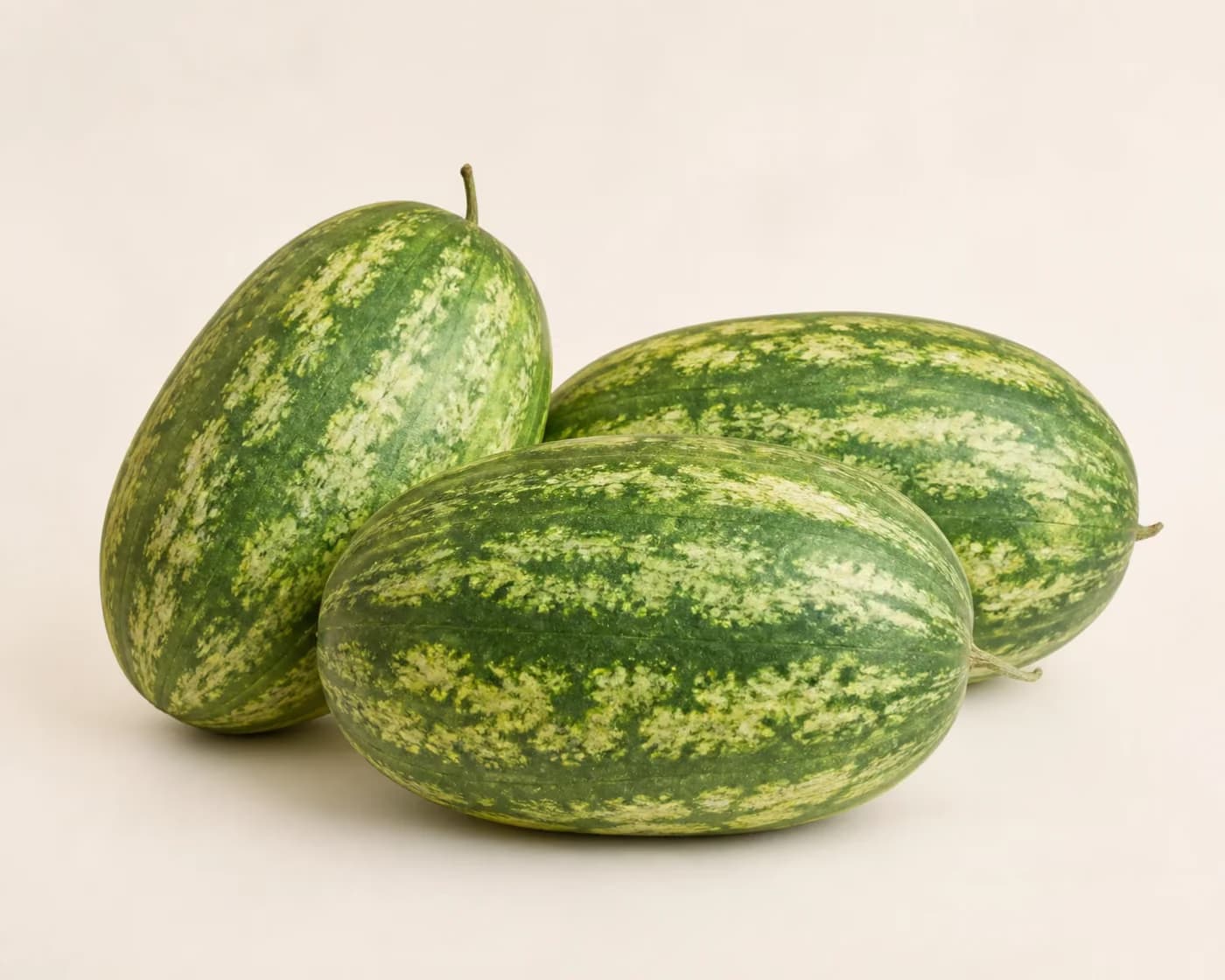 Fresh Kiran Watermelon arranged on a warm off-white surface.