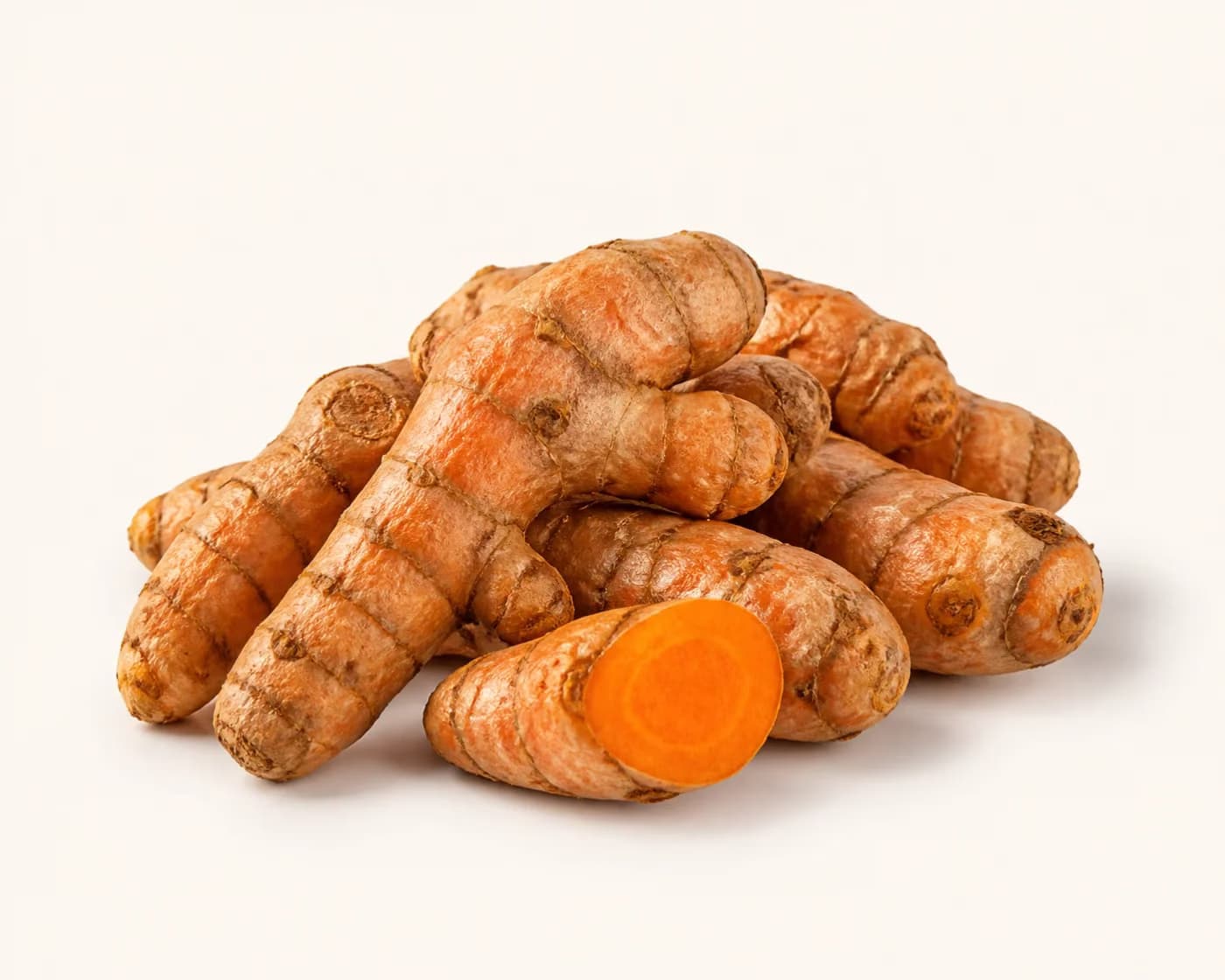 Fresh Raw Turmeric arranged on a warm off-white surface.