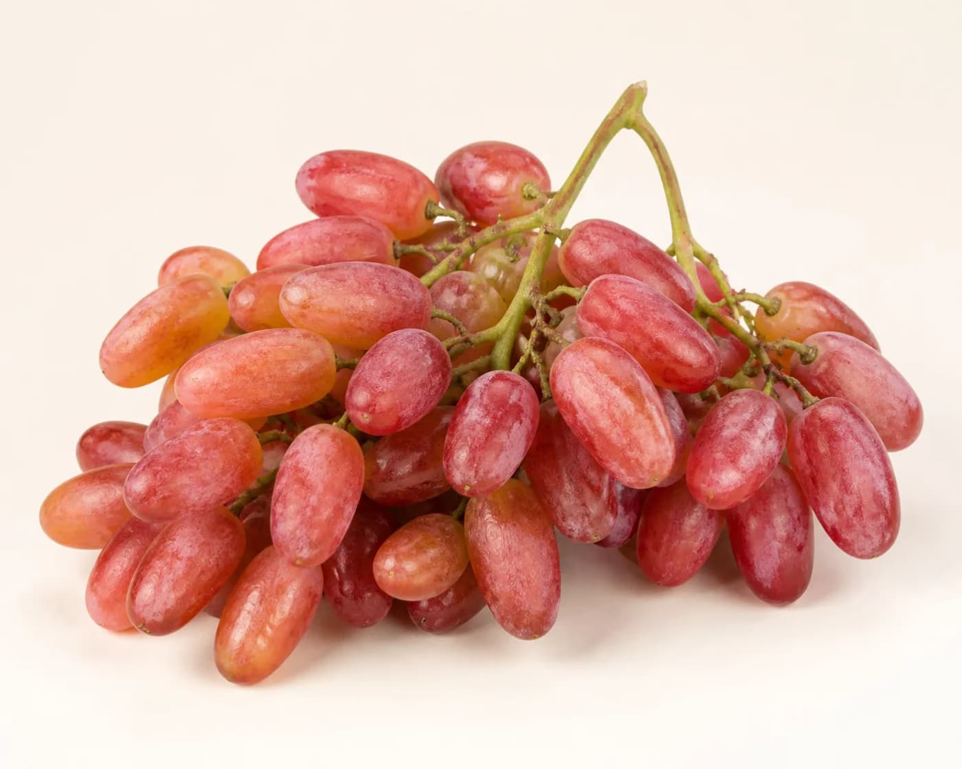 Fresh Flame Seedless Grapes arranged on a warm off-white surface.