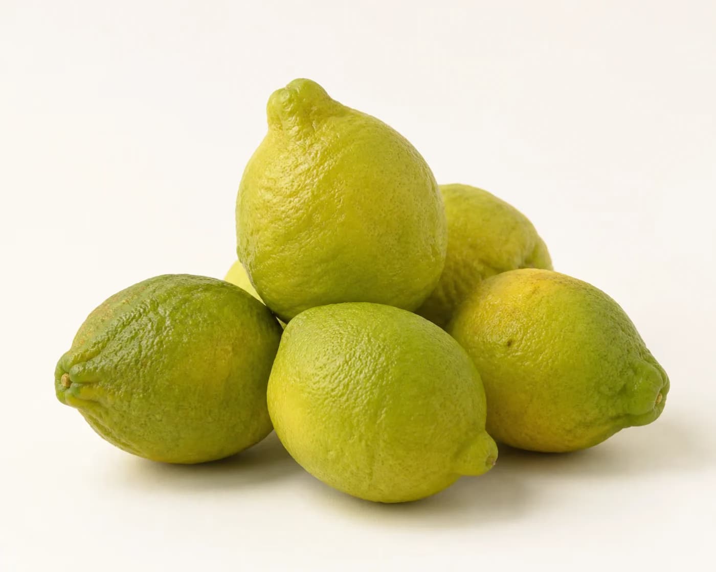 Fresh Gondhoraj Lemon arranged on a warm off-white surface.