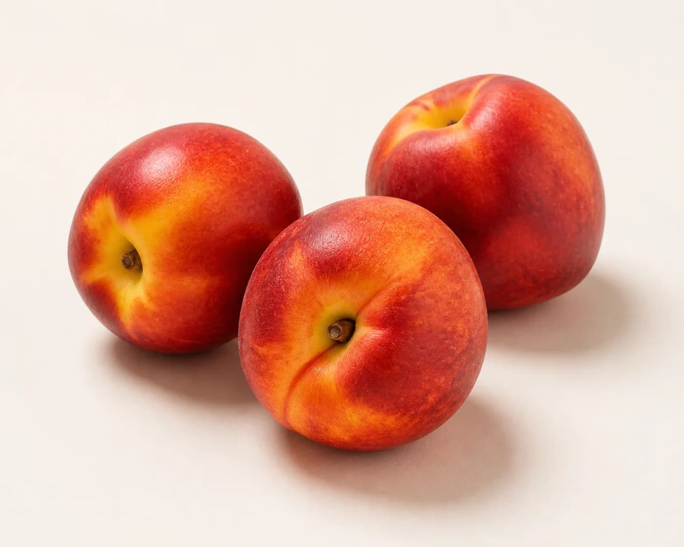 Fresh Nectarine arranged on a warm off-white surface.