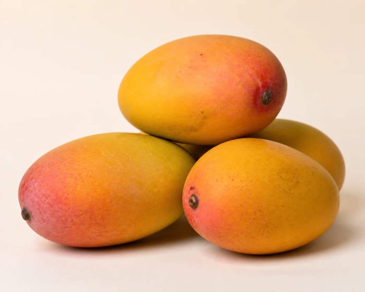 Fresh Gulab Khas Mango arranged on a warm off-white surface.