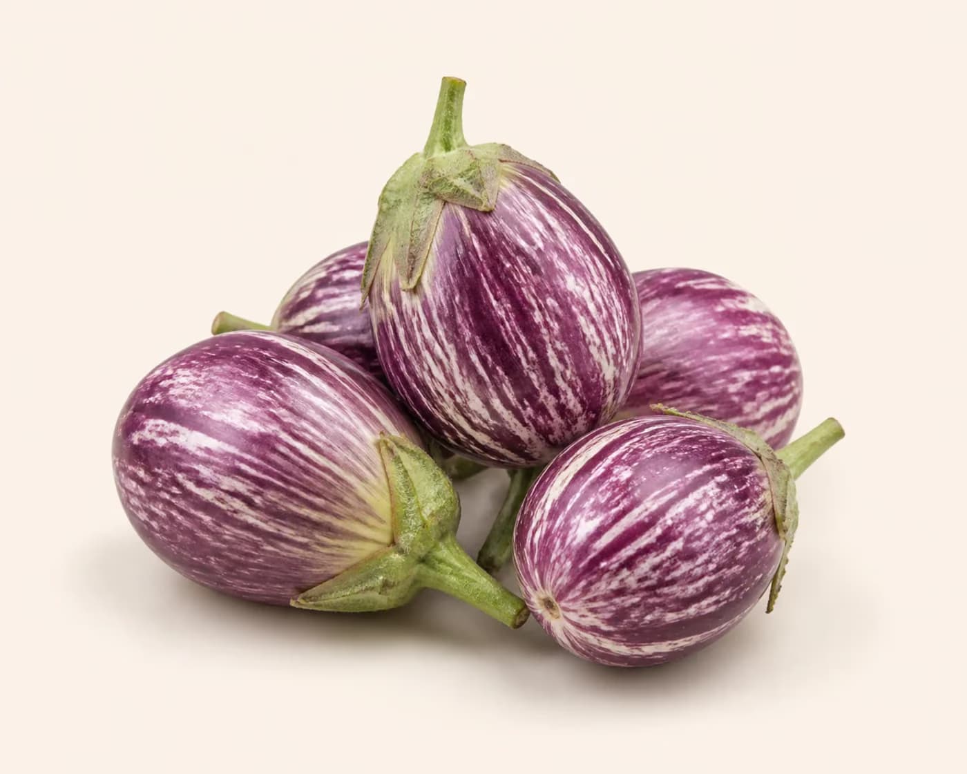 Fresh Striped Brinjal arranged on a warm off-white surface.