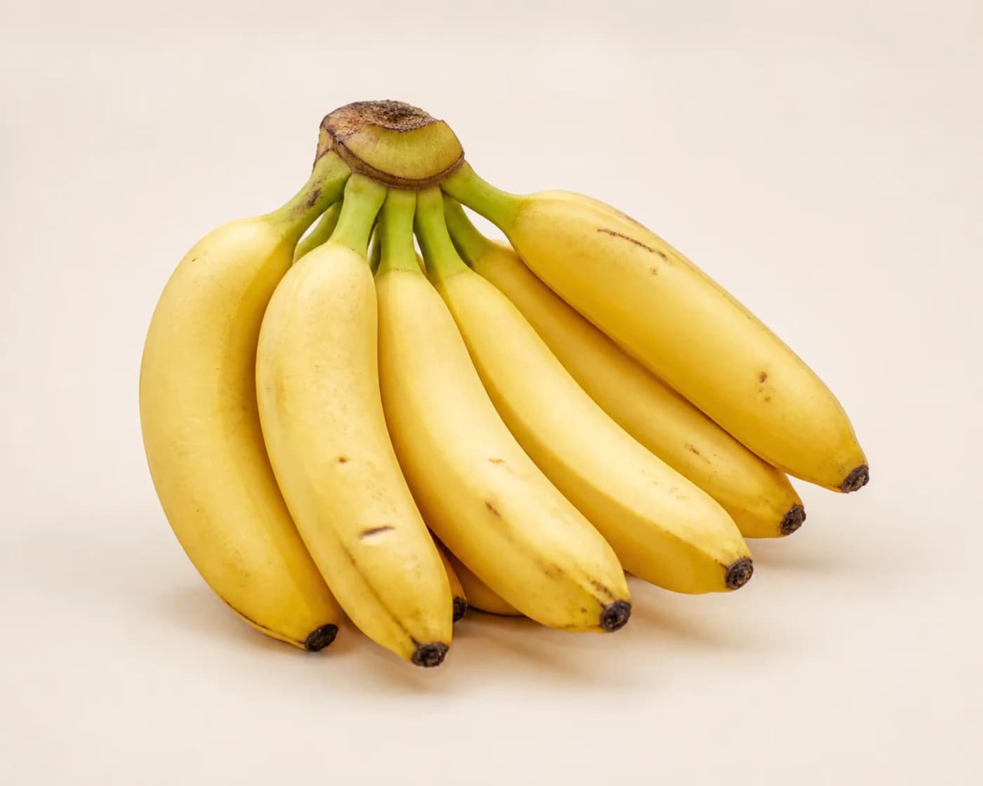 Fresh Poovan Banana arranged on a warm off-white surface.