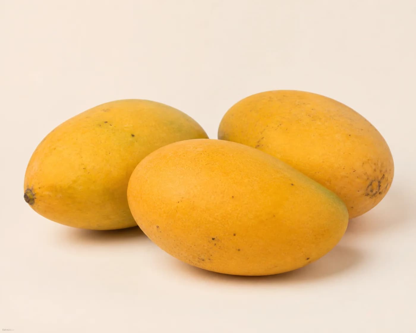 Fresh Banganapalli Mango arranged on a warm off-white surface.