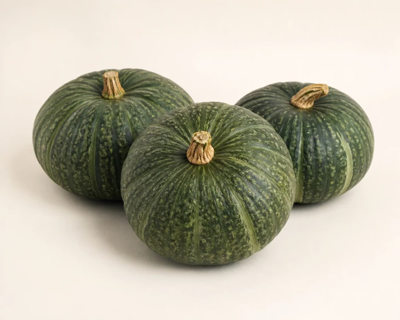 Fresh Green Pumpkin arranged on a warm off-white surface.