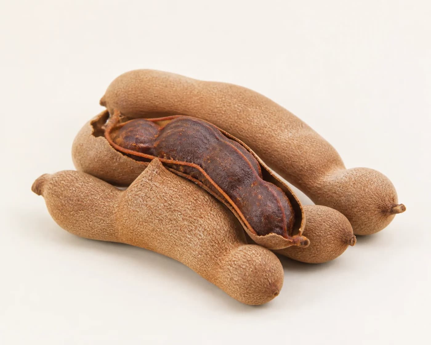 Fresh Fresh Tamarind arranged on a warm off-white surface.