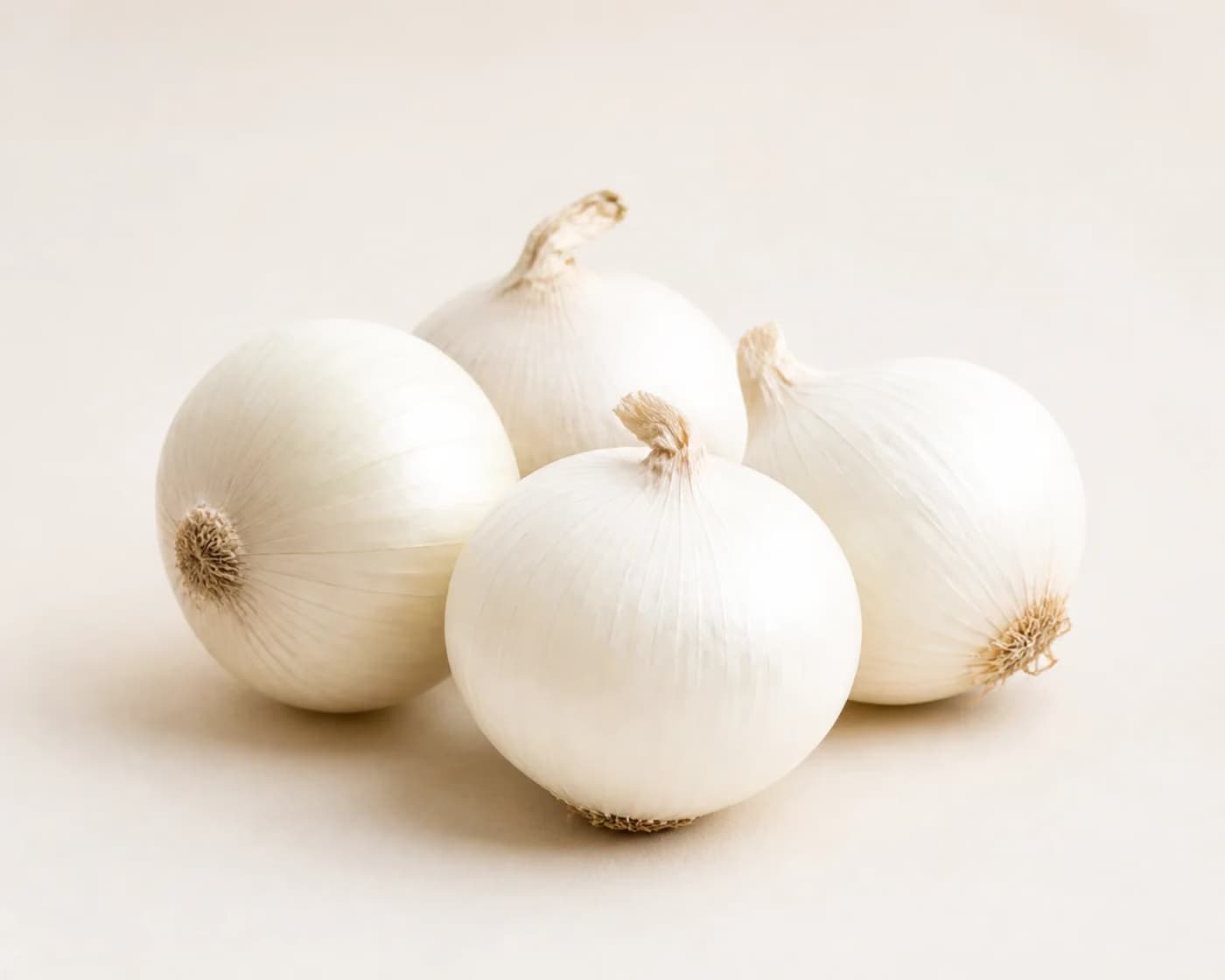 Fresh White Onion arranged on a warm off-white surface.