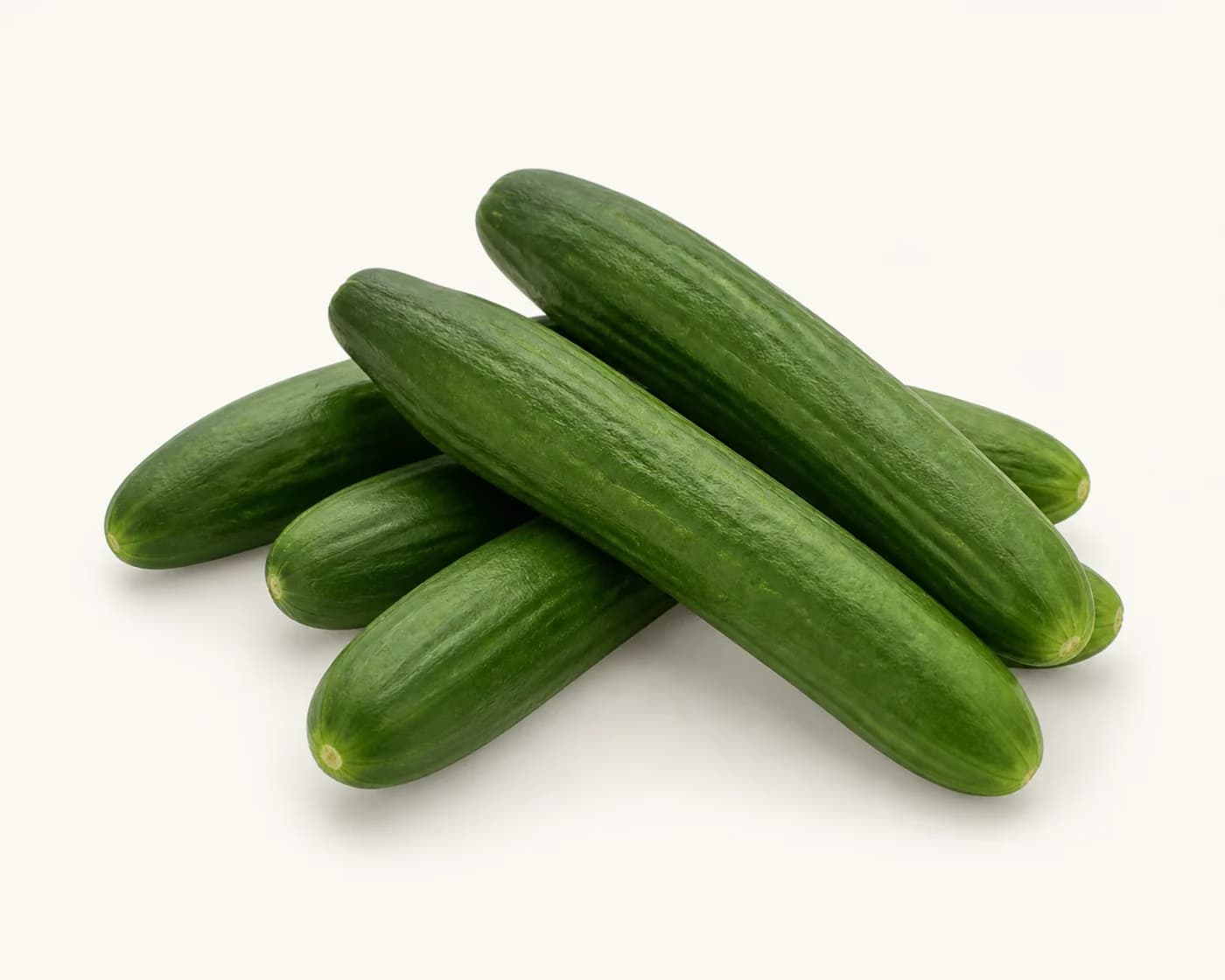 Fresh Persian Cucumber arranged on a warm off-white surface.