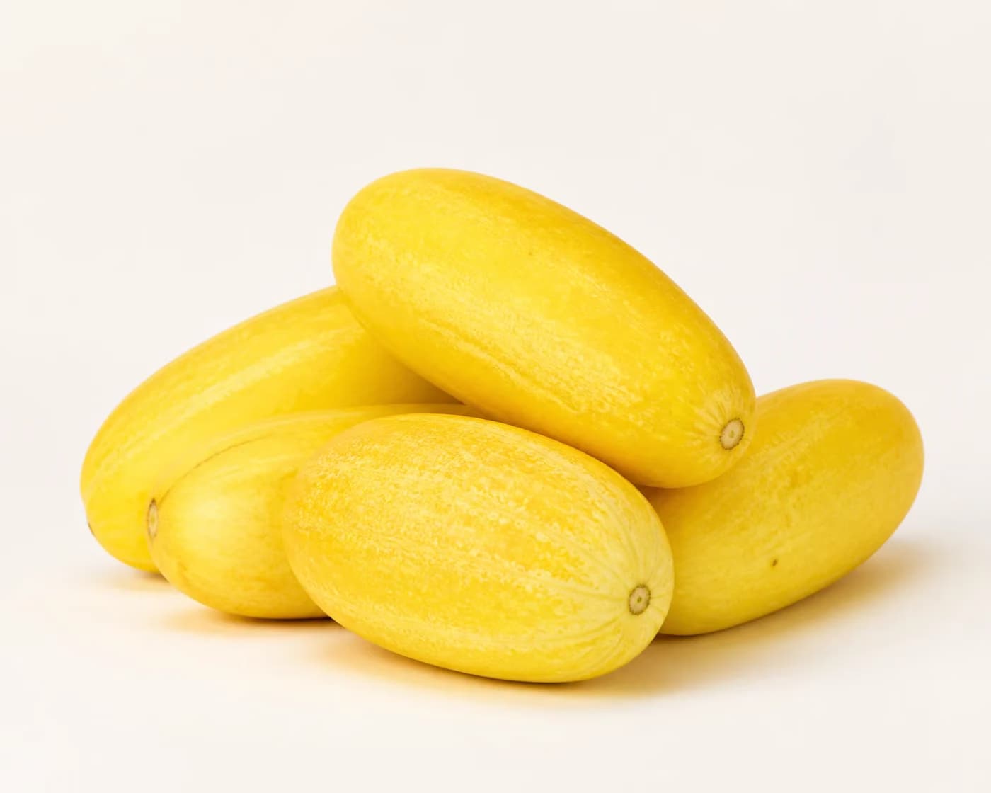 Fresh Yellow Cucumber arranged on a warm off-white surface.