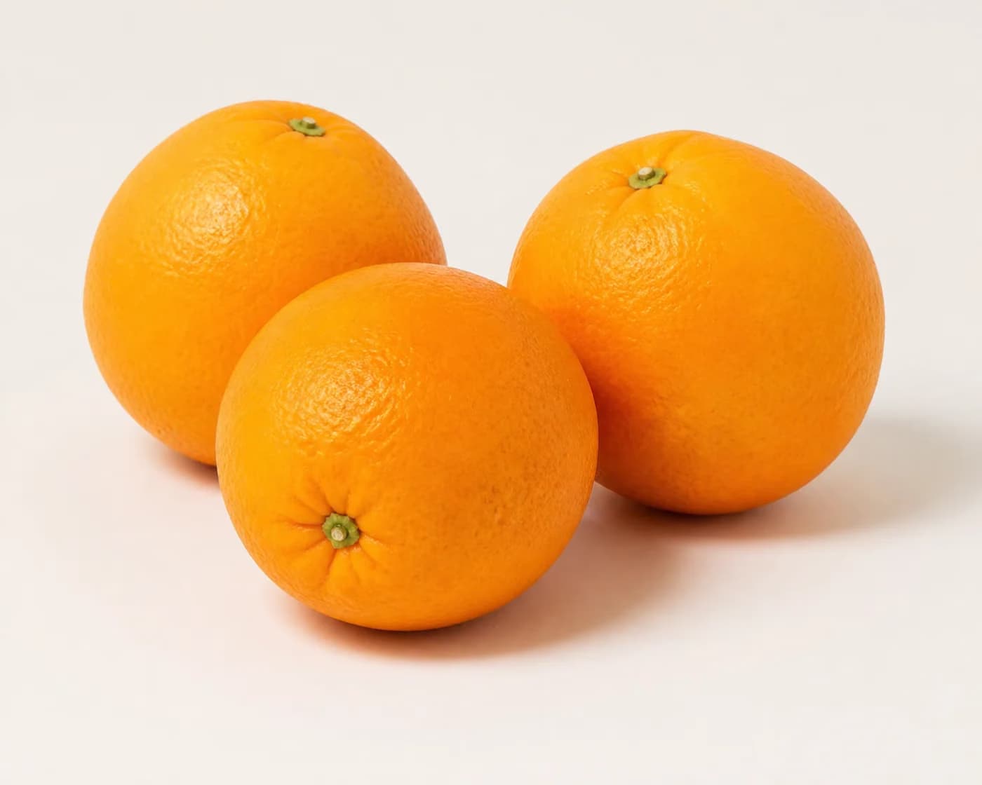 Fresh Valencia Orange arranged on a warm off-white surface.