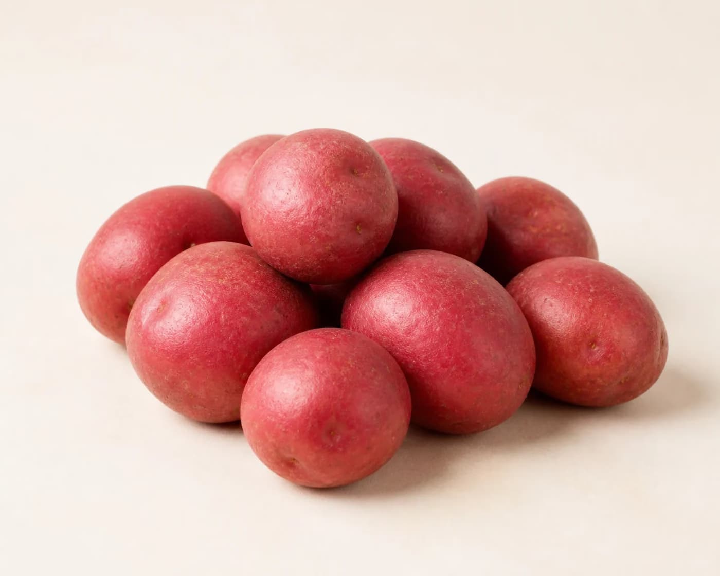Fresh Red Skin Potato arranged on a warm off-white surface.