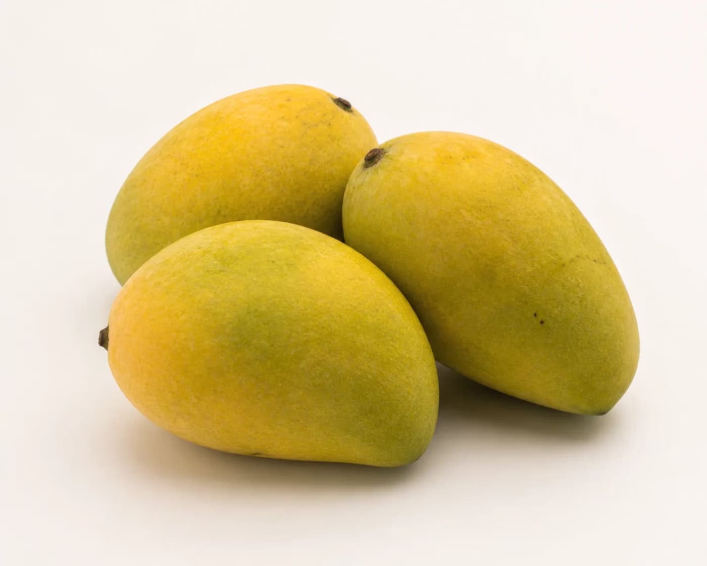 Fresh Chausa Mango arranged on a warm off-white surface.