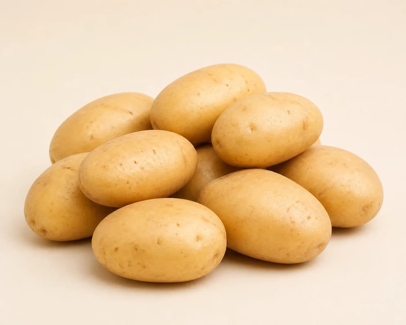 Fresh Kufri Chipsona Potato arranged on a warm off-white surface.