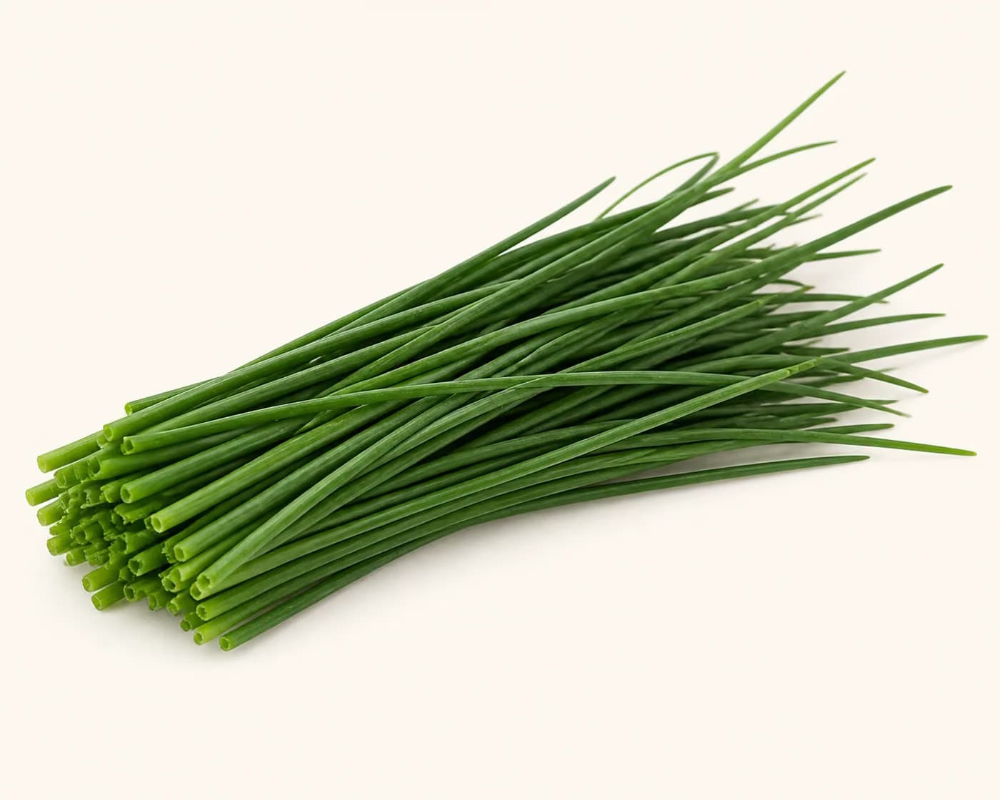 Fresh Chives arranged on a warm off-white surface.