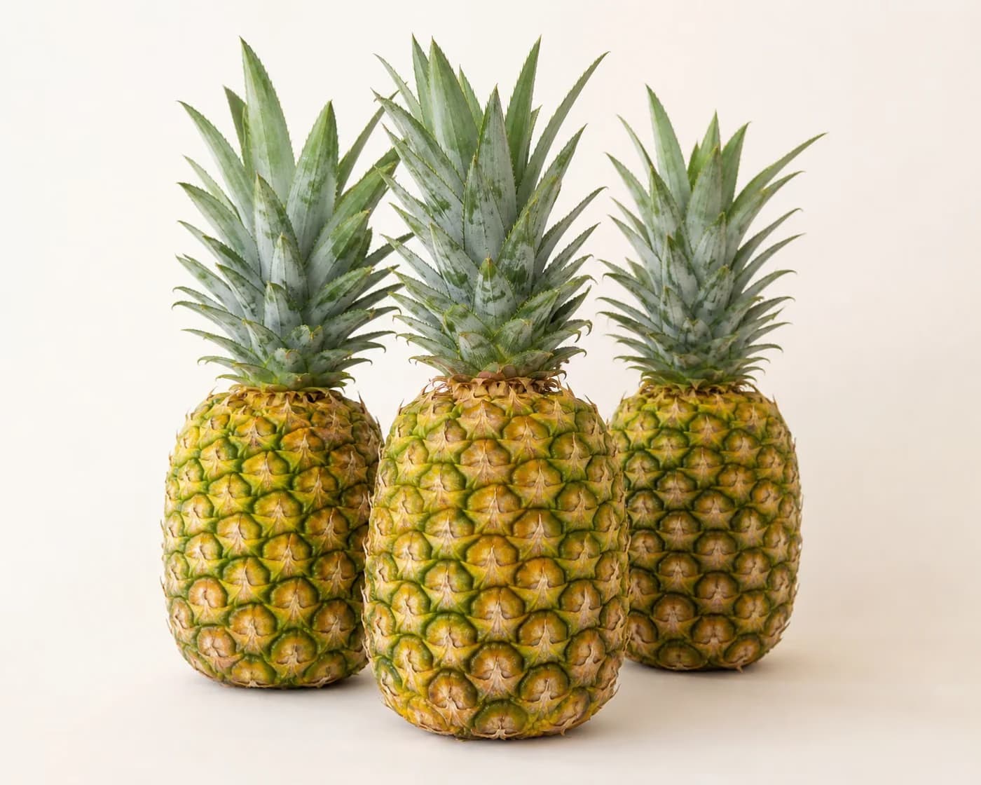 Fresh Kew Pineapple arranged on a warm off-white surface.