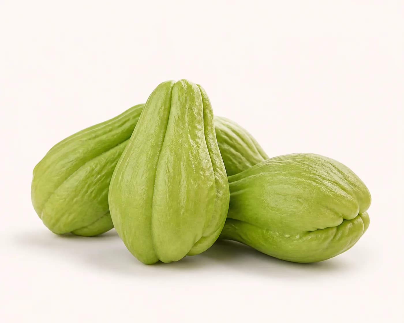 Fresh Chayote arranged on a warm off-white surface.