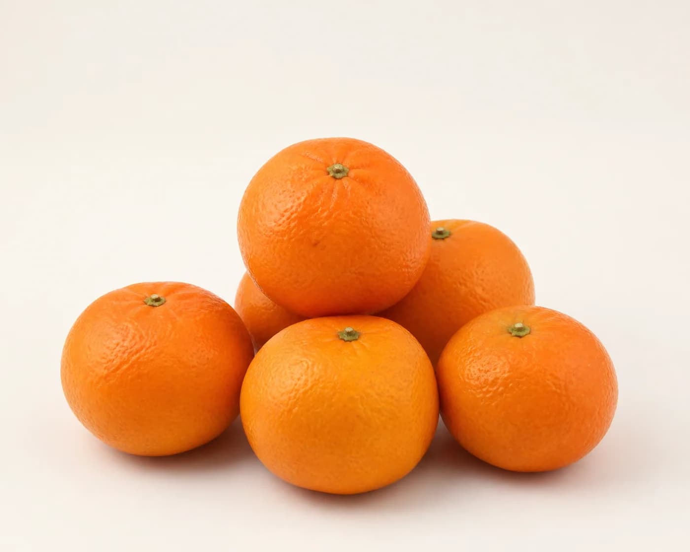 Fresh Nagpur Mandarin arranged on a warm off-white surface.