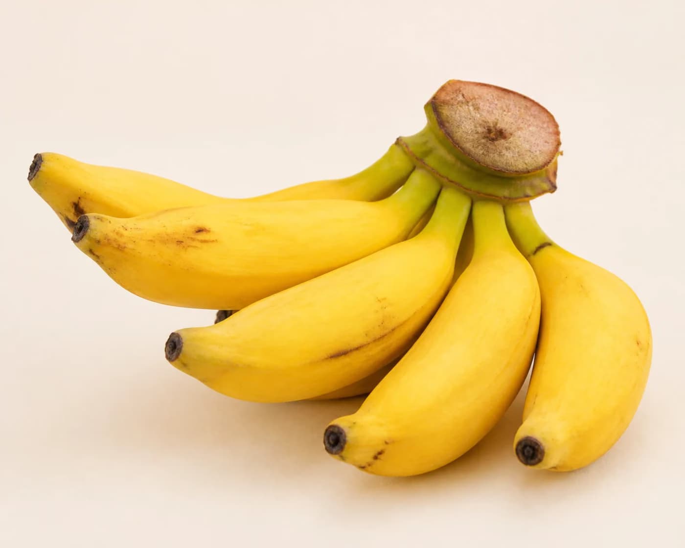 Fresh Yelakki Banana arranged on a warm off-white surface.