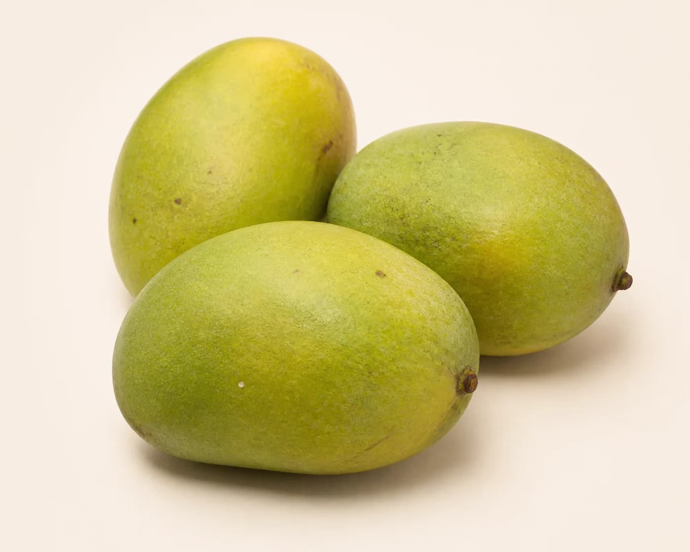 Fresh Himsagar Mango arranged on a warm off-white surface.