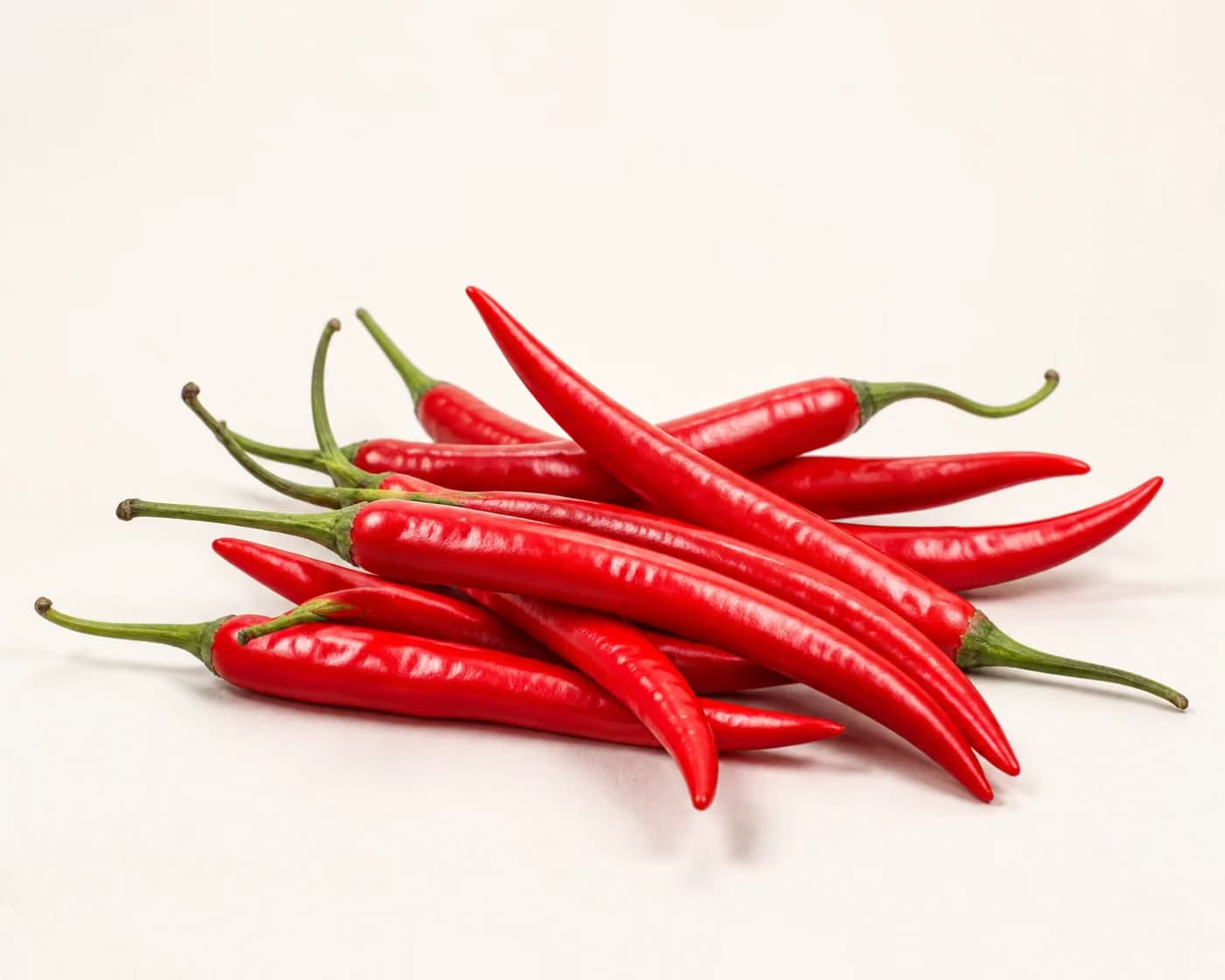 Fresh Fresh Red Chilli arranged on a warm off-white surface.