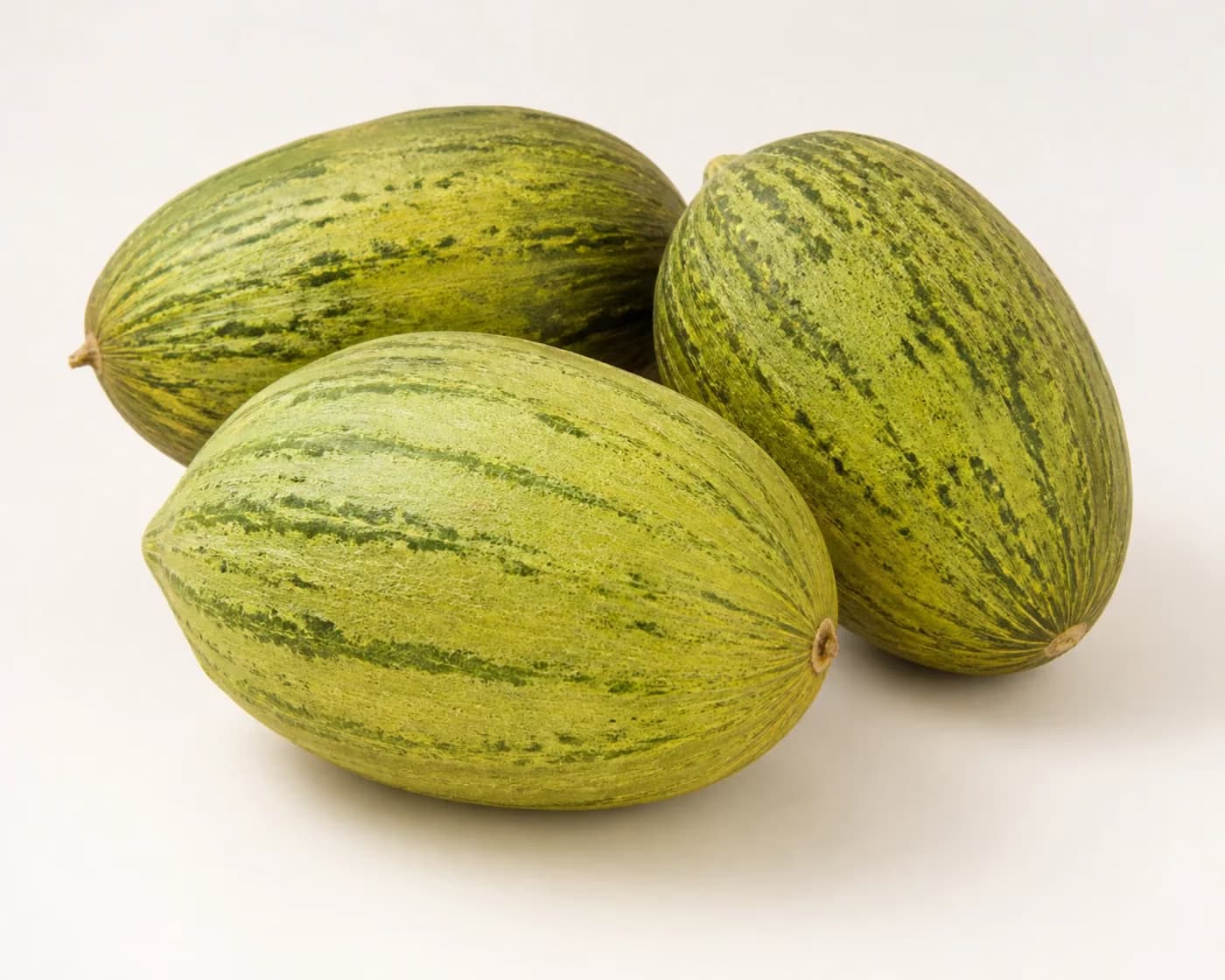 Fresh Sarda Melon arranged on a warm off-white surface.