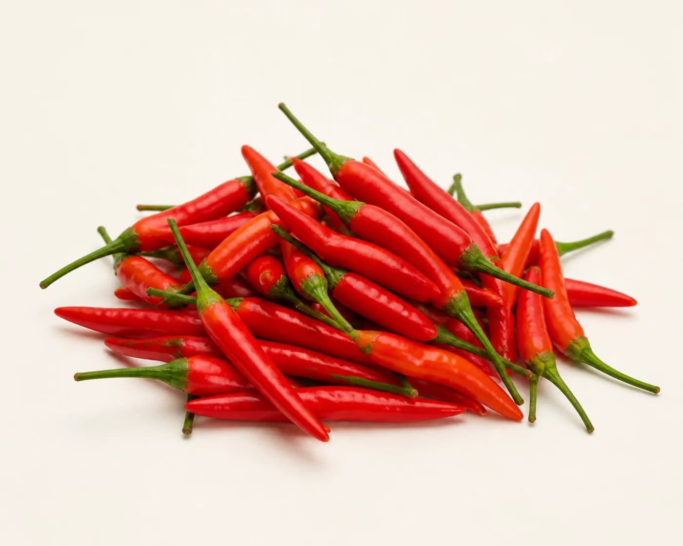 Fresh Bird's Eye Chilli arranged on a warm off-white surface.