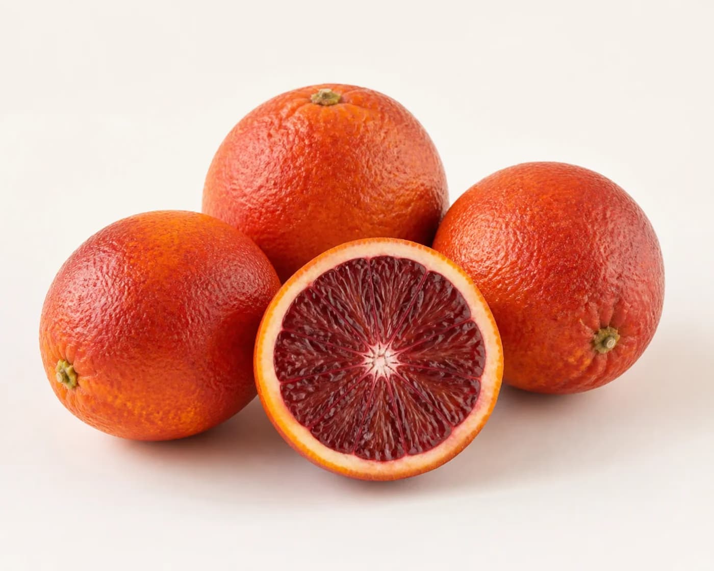 Fresh Blood Orange arranged on a warm off-white surface.