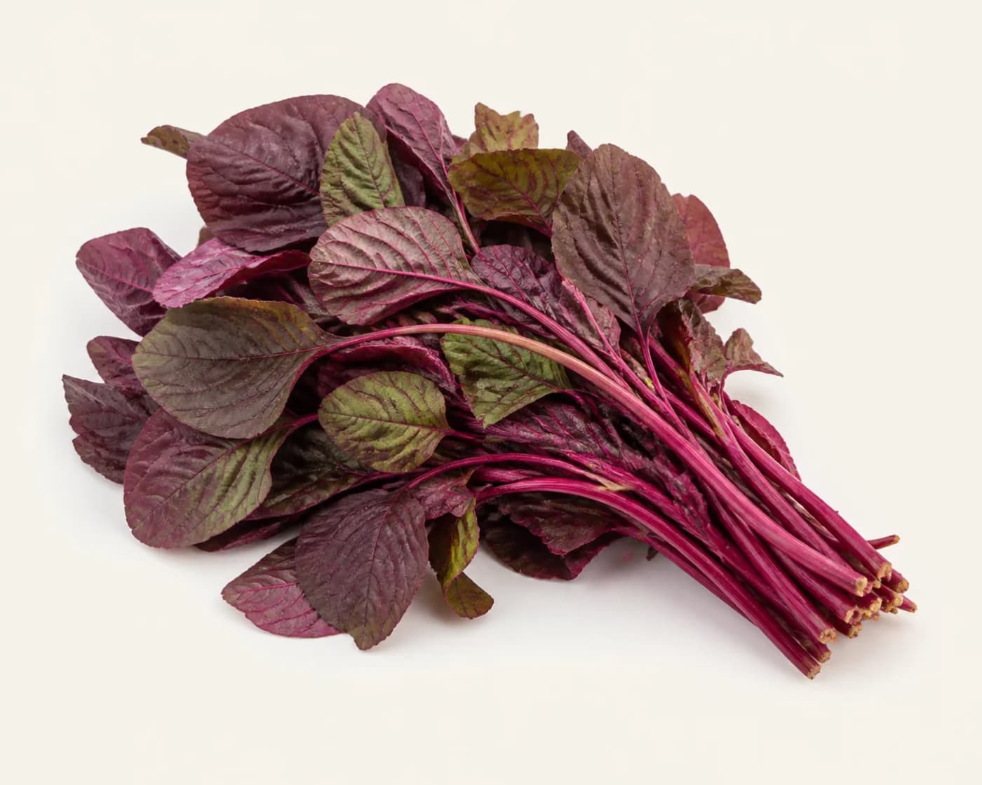 Fresh Red Amaranth arranged on a warm off-white surface.