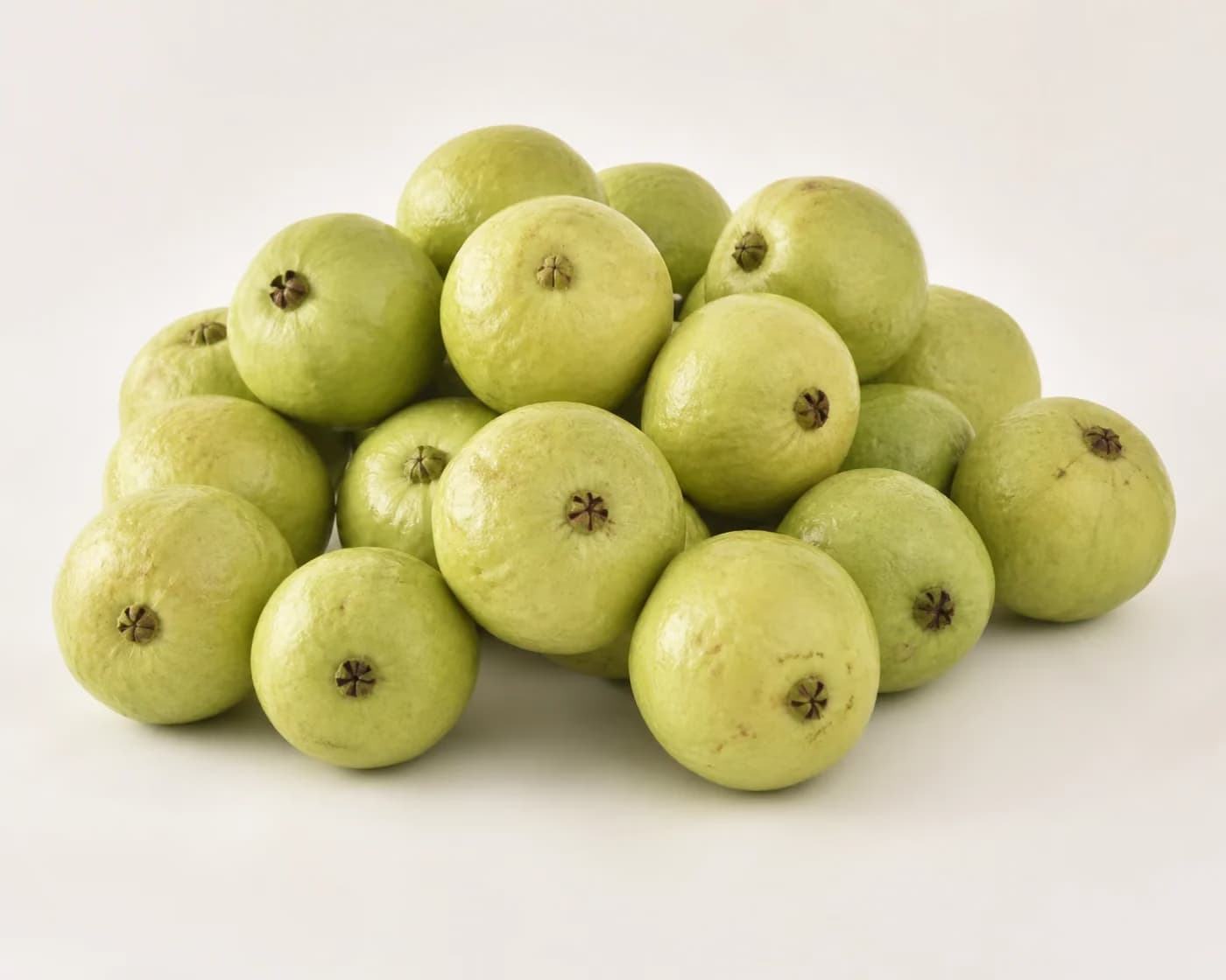 Fresh Lucknow 49 Guava arranged on a warm off-white surface.