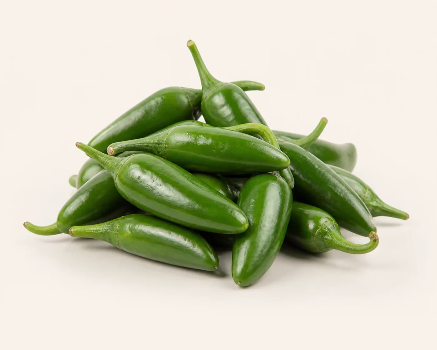 Fresh Bullet Chilli arranged on a warm off-white surface.