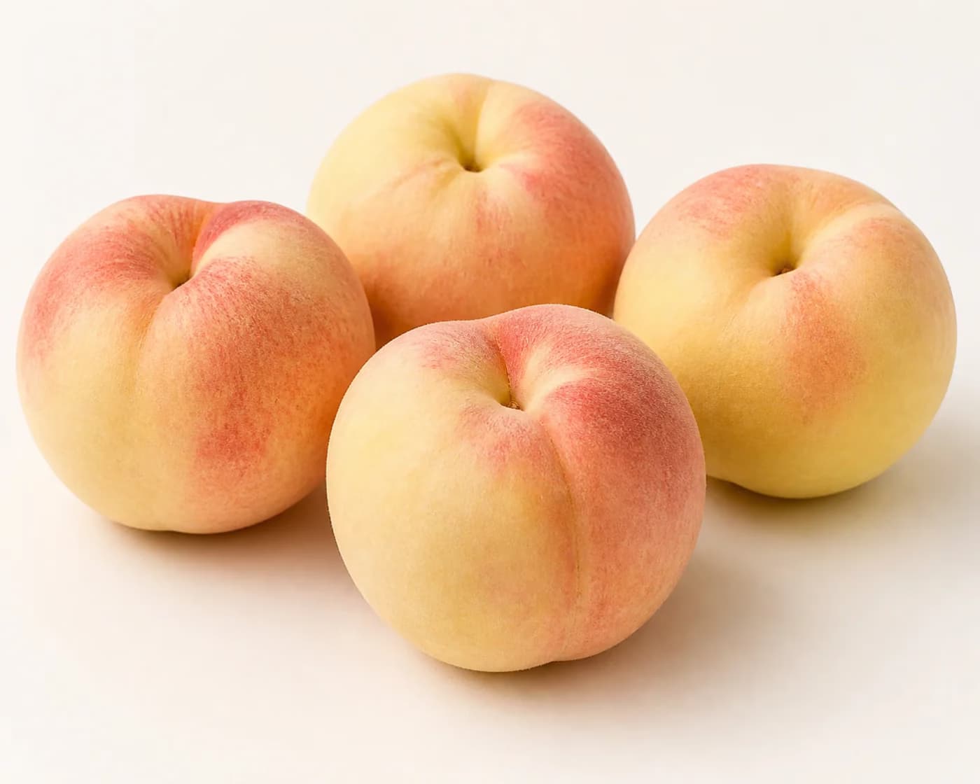 Fresh White Peach arranged on a warm off-white surface.
