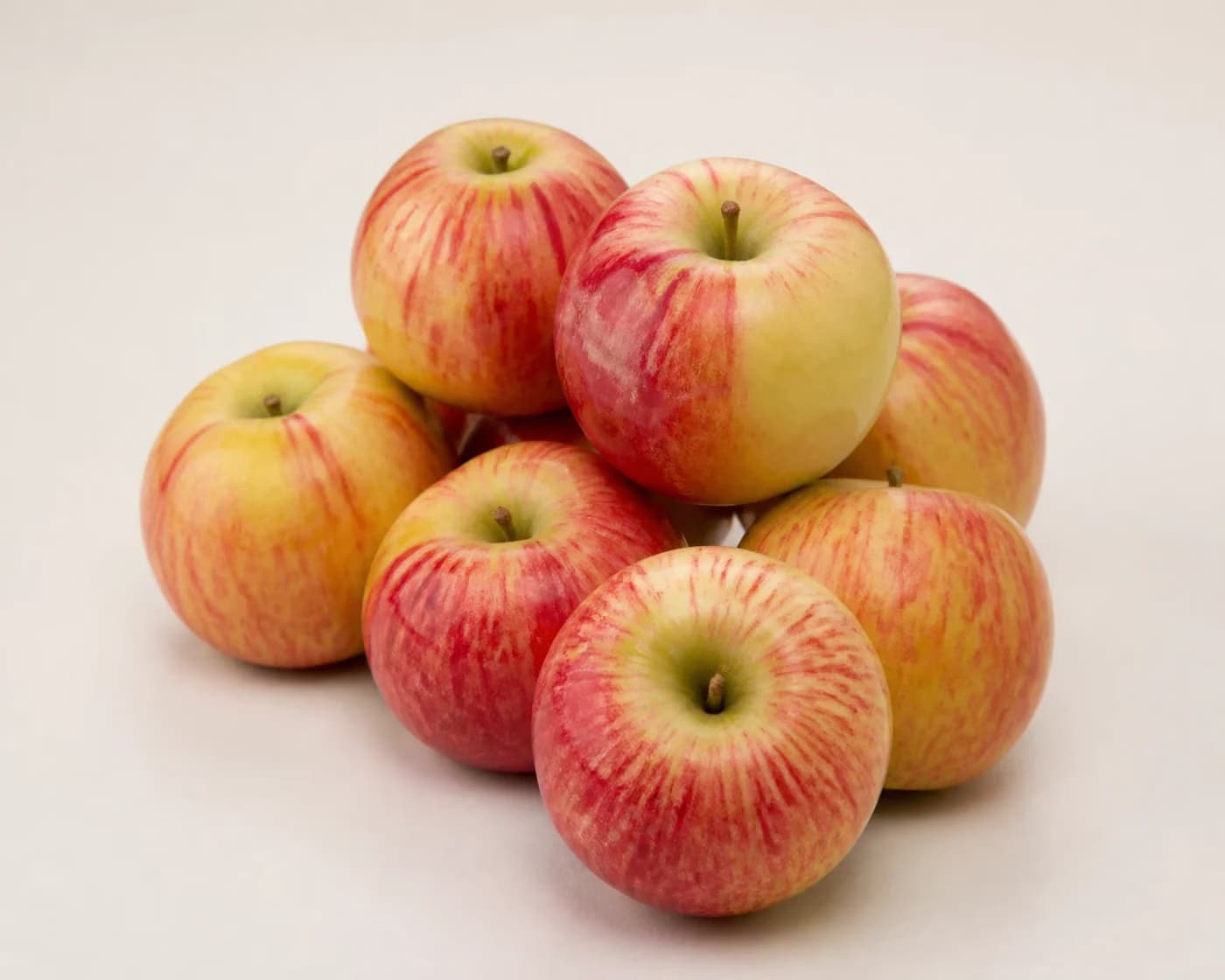 Fresh Tydeman Apple arranged on a warm off-white surface.