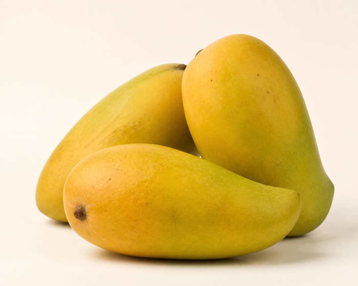 Fresh Dasheri Mango arranged on a warm off-white surface.