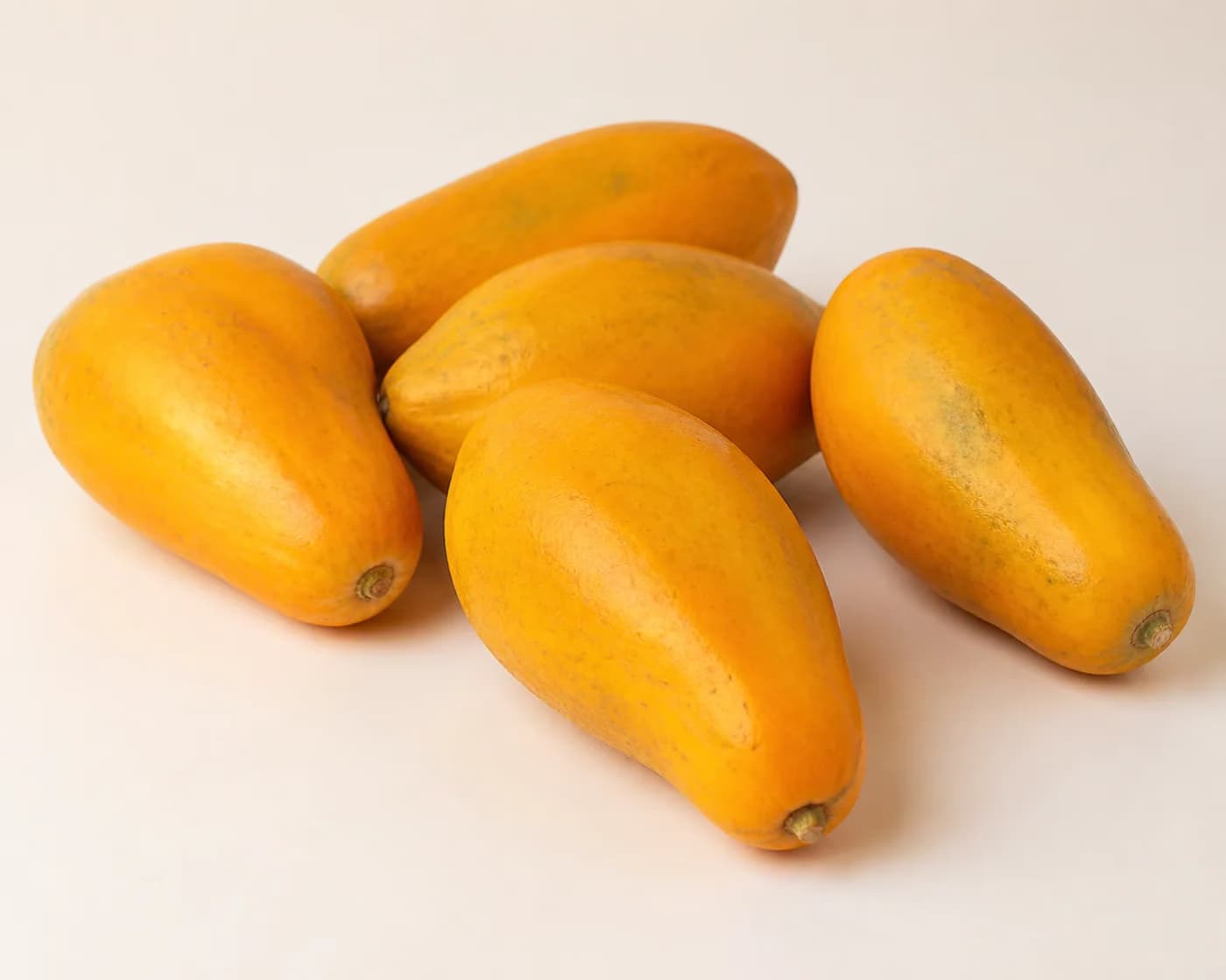 Fresh Taiwan Papaya arranged on a warm off-white surface.